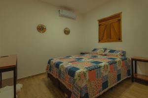 ein Schlafzimmer mit einem Bett mit einer Steppdecke darauf in der Unterkunft Chalés Samambaia 1 in Bananeiras + 9 Fotos