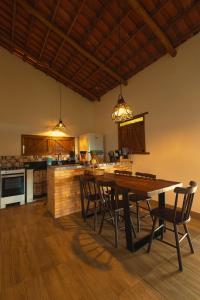 eine große Küche mit Holztisch und Stühlen in der Unterkunft Chalés Samambaia 1 in Bananeiras