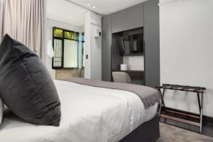 ein Schlafzimmer mit großem Bett und Fenster in der Unterkunft Calais Heritage House Apartments in Kapstadt