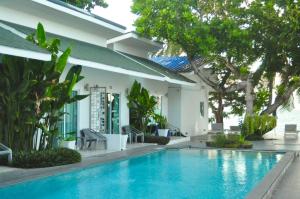 a swimming pool in front of a house at Baanfah Resort Samui in Mae Nam