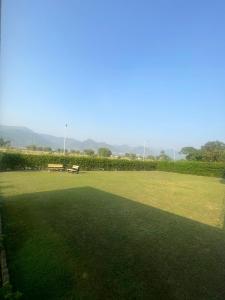 a park with a bench in the middle of a field at Dream Inn Guest House Islamabad in Islamabad