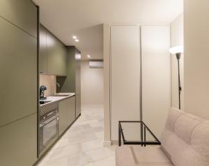 un salon avec un canapé et une cuisine dans l'établissement Apartamentos Turísticos Insulae , by CartagenaSpain, à Carthagène