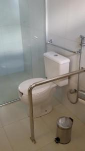 a bathroom with a white toilet and a shower at Pousada Da Serra in Bananeiras
