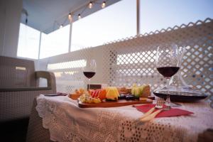 ein Tisch mit einem Teller Essen und zwei Gläsern Wein in der Unterkunft 리사 스테이 로맨틱 프라이빗 테라스, 무료주차, 2룸 in Daegu