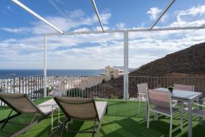 un patio avec une table et des chaises et l'océan dans l'établissement Apartamento Cervantes con terraza y vistas al mar, à Carboneras