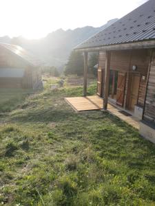 dom z drewnianym tarasem obok domu w obiekcie Chalet 6-8 couchages à la Joue du Loup w mieście Dévoluy