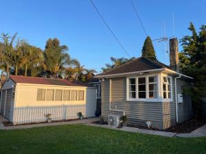 a small house in a yard with at Watts, A Cosy Escape in Hamilton
