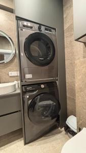 una lavatrice e un'asciugatrice in un piccolo bagno di Nova ApartHotel a Chişinău