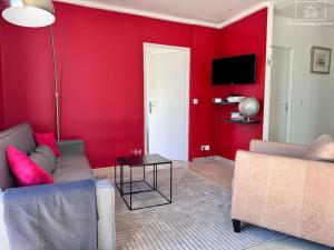 a red living room with a couch and a table at La Gacélyte Piscine privée joli bas de villa in Carqueiranne
