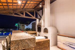 an outdoor kitchen with an outdoor pizza oven at Casa La Baule in Aquiraz