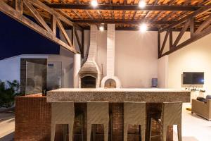 a large kitchen with a fireplace in a room at Casa La Baule in Aquiraz