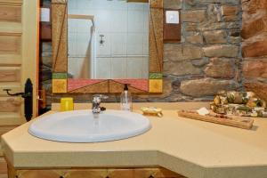 a sink in a bathroom with a stone wall at Casa Rural Tio Eloy in Fabero +20 photos