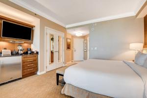 Un dormitorio con una gran cama blanca y una cocina. en MGM Signature Towers by FantasticStay, en Las Vegas