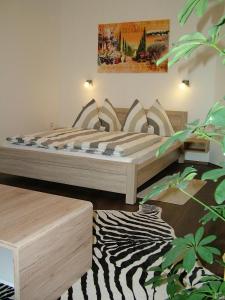 ein Schlafzimmer mit einem Bett und einem Zebra-Teppich in der Unterkunft Korzó Apartman in Kőszeg