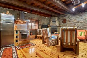 a kitchen with a stainless steel refrigerator and wooden floors at Casa Rural Tio Eloy in Fabero