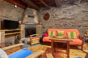 a living room with a couch and a fireplace at Casa Rural Tio Eloy in Fabero