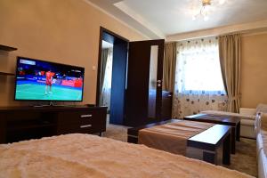 Televízia a/alebo spoločenská miestnosť v ubytovaní Luxusný apartmán v Hoteli Panorama s výhľadom na hory