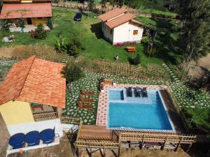 einen Blick über einen Pool mit Stühlen und ein Haus in der Unterkunft Chalés Samambaia 1 in Bananeiras