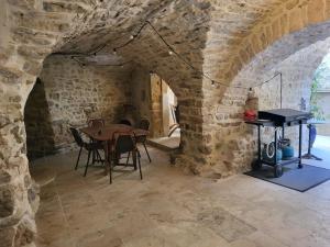 a dining room with a table and a piano at La grange in Aspères
