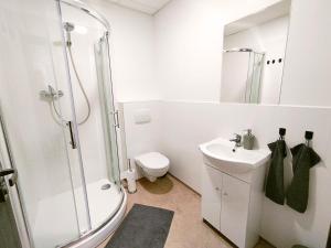 a bathroom with a shower and a toilet and a sink at Dimael Hostel & Apartments in Bratislava +111 photos
