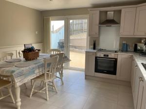 a kitchen with a table and chairs and a kitchen with a table and a table at Grovehouse in Portstewart