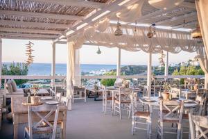 a restaurant with tables and chairs and a view of the ocean at Althea Boutique Hotel - Adults Only in Amoopi