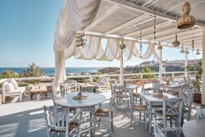 a patio with tables and chairs and a view of the ocean at Althea Boutique Hotel - Adults Only in Amoopi