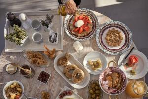 a table with plates of food on it at Althea Boutique Hotel - Adults Only in Amoopi