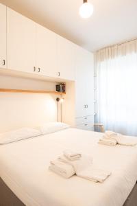 a bedroom with a white bed with white cabinets at Moderno bilocale sui Navigli - Mirable PM in Milan