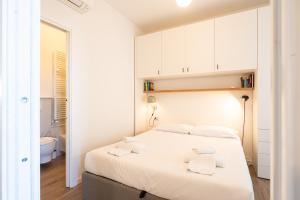 a bedroom with a white bed and a bathroom at Moderno bilocale sui Navigli - Mirable PM in Milan +42 photos