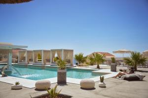 a man and a woman sitting next to a swimming pool at Althea Boutique Hotel - Adults Only in Amoopi