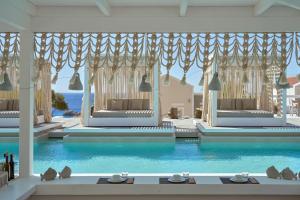a room with a swimming pool with blue water at Althea Boutique Hotel - Adults Only in Amoopi