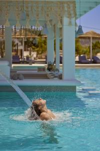 a person in the water in a swimming pool at Althea Boutique Hotel - Adults Only in Amoopi