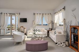 a living room with white furniture and a glass table at Althea Boutique Hotel - Adults Only in Amoopi