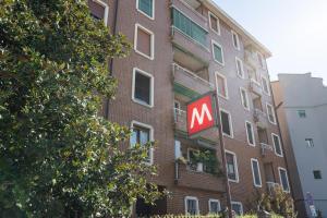 a large brick building with a m sign in front of it at Moderno bilocale sui Navigli - Mirable PM in Milan