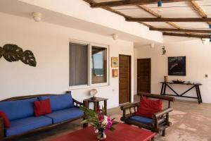 a living room with a blue couch and two chairs at Monterrico Resort in La Candelaria