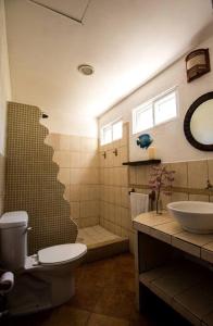 a bathroom with a toilet and a sink and a shower at Monterrico Resort in La Candelaria
