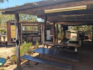a wooden pergola with two benches under it at Blackall Caravan Park in Blackall