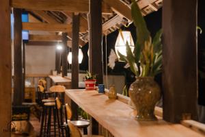 a bar with a vase on a table with chairs at Dìn's home in Ha Giang