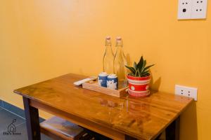 a table with three bottles and a potted plant on it at Dìn's home in Ha Giang