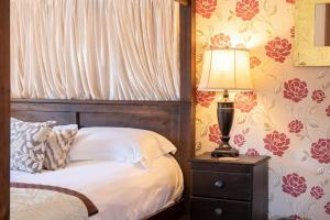 une chambre avec un lit et une lampe sur une table de chevet dans l'établissement Wild Oats Lodge 3, Yellowtop Country Park, à York 11 autres photos