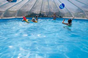 a group of people playing in a swimming pool at Familiengästehaus Ingrid in Sankt Martin am Tennengebirge