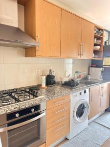 a kitchen with a stove and a washing machine at Lisbon Room S Joao Talha in São João da Talha