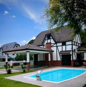 a house with a swimming pool in front of it at Villa D'Astana,A'Famosa Resort Pool-BBQ-Karaoke in Alor Gajah +37 photos