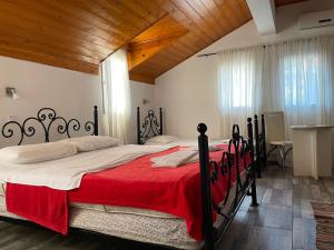 a bedroom with a large bed with a red blanket at Skadar Lake Family Resort in Rijeka Crnojevića