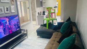 sala de estar con sofá y silla verde en Roloma Property, en East London