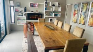 Un comedor con mesa y sillas de madera. en Roloma Property, en East London