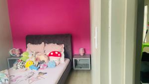 una habitación rosa con una cama con animales de peluche. en Roloma Property, en East London 2 fotos más