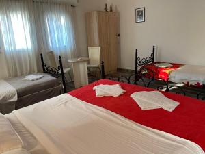 a hotel room with two beds and a red blanket at Skadar Lake Family Resort in Rijeka Crnojevića