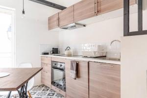a kitchen with wooden cabinets and a wooden table at L’écurie location saisonnière in Tavernes